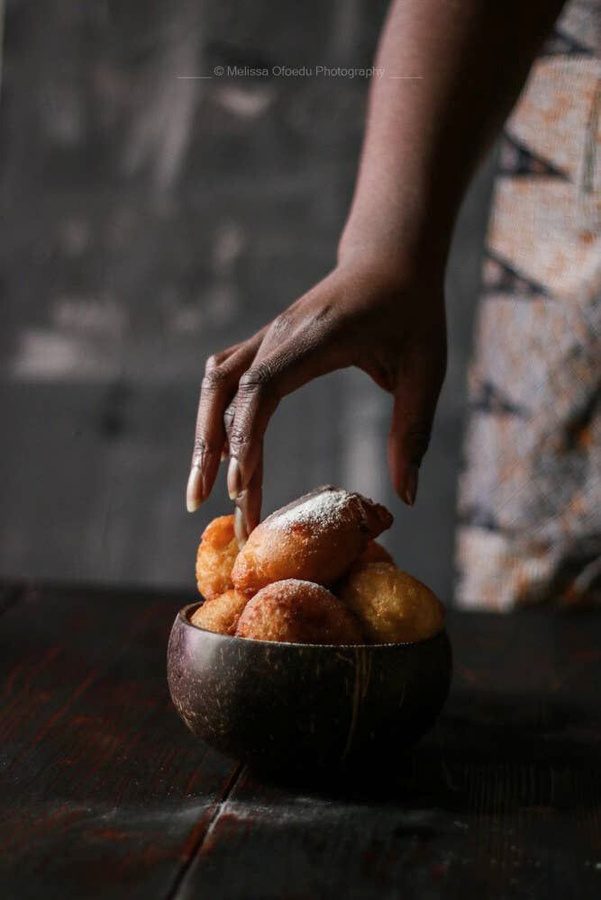 Main déposant des fruits dans une calebasse